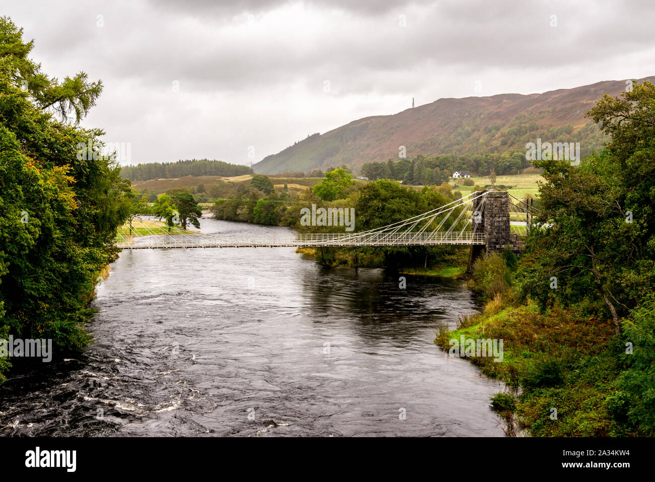 Una vista della conicità storico ponte di sospensione di Oich appeso al di là del fiume vicino Aberchalder, Scozia Foto Stock