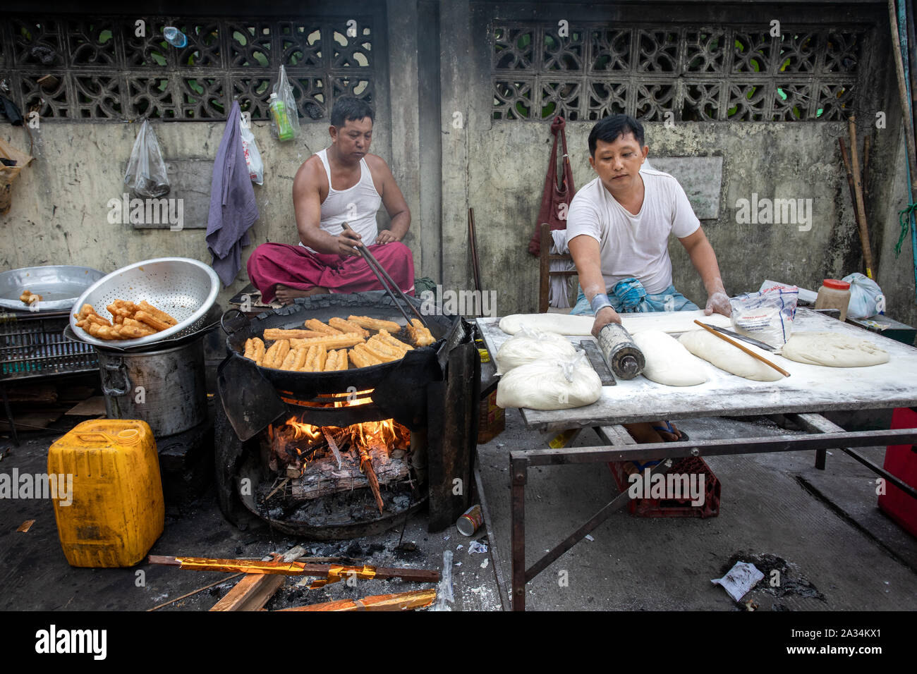 Le persone che si preparano tradizionale cibo birmano sulla strada di Yangon. Asian street food concept. Foto Stock