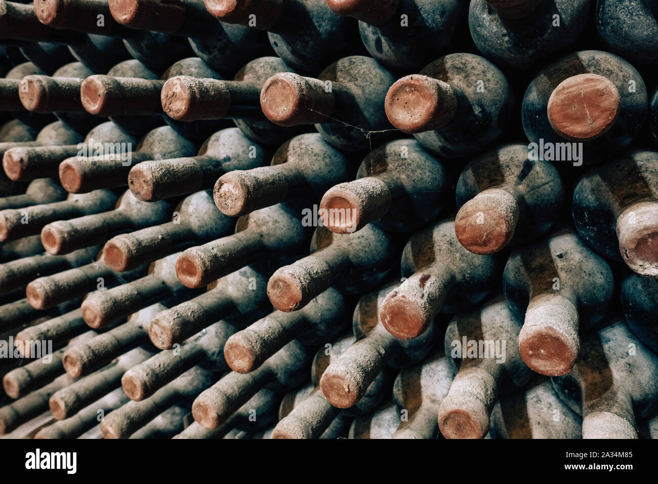 Le bottiglie di vino impilati nella vecchia cantina close-up sullo sfondo Foto Stock