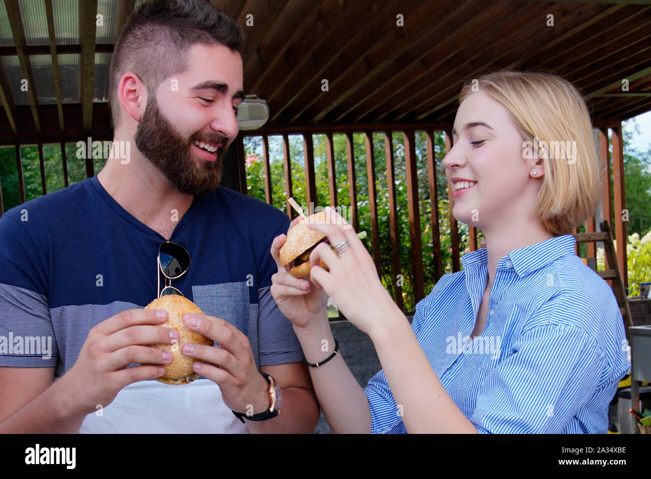 Coppia giovane mangiare hamburger Foto Stock