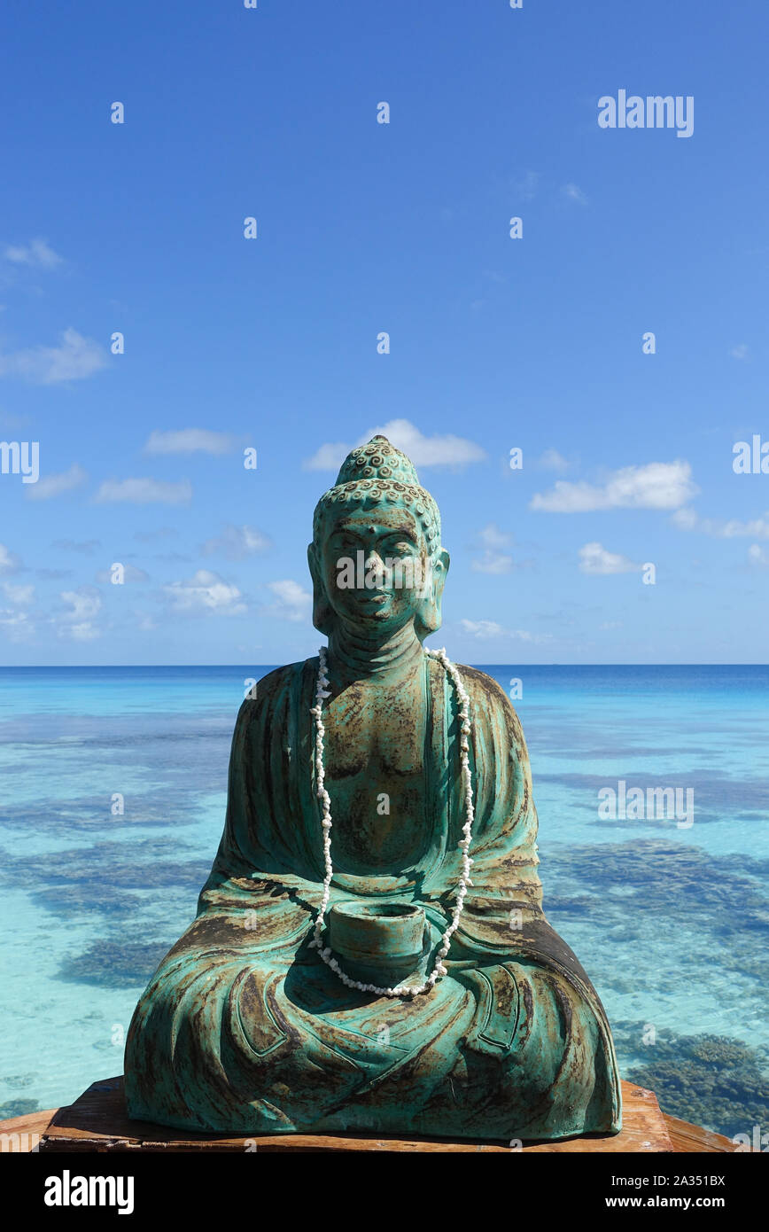 Una figura di Buddha nella parte anteriore di una laguna turchese sull isola di Fakarava in Polinesia francese nel Sud del Pacifico; spazio di copia Foto Stock