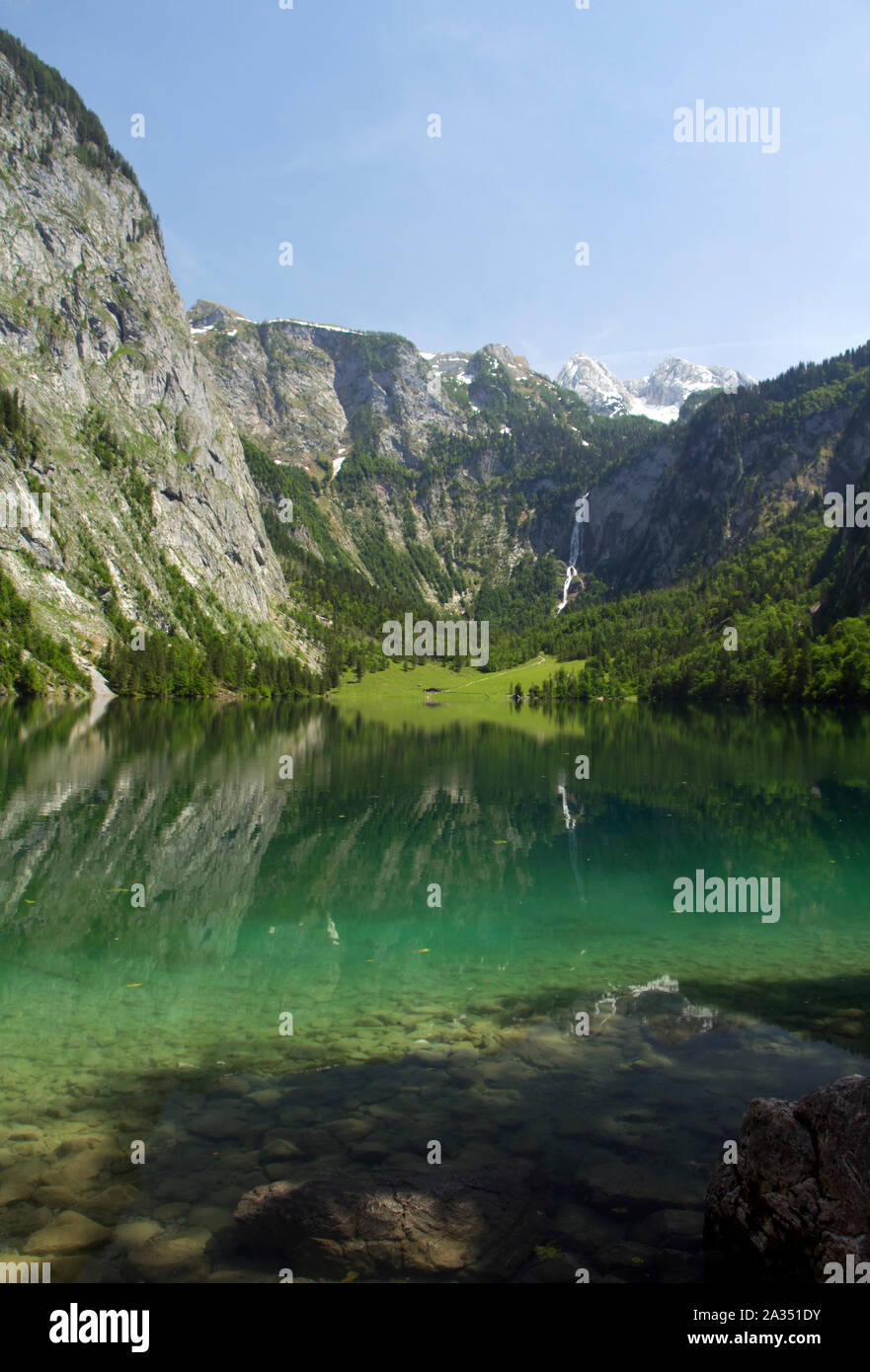 La bellezza del lago Konigssee nelle Alpi. Verde prato und cascata in Baviera. Germania Paesaggio estivo Foto Stock