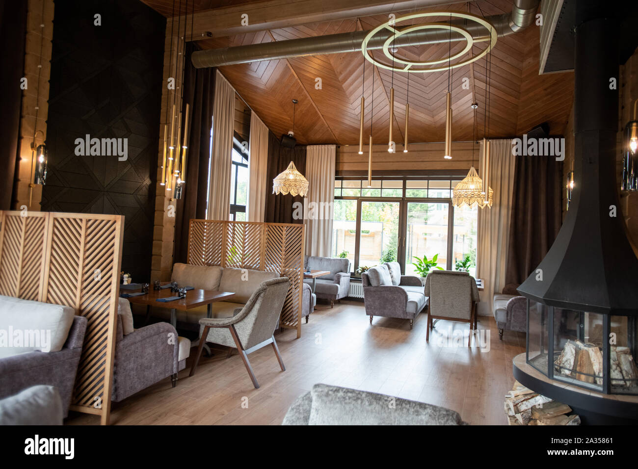 Interno del lussuoso ristorante con pareti in legno e lampadari sofisticati Foto Stock