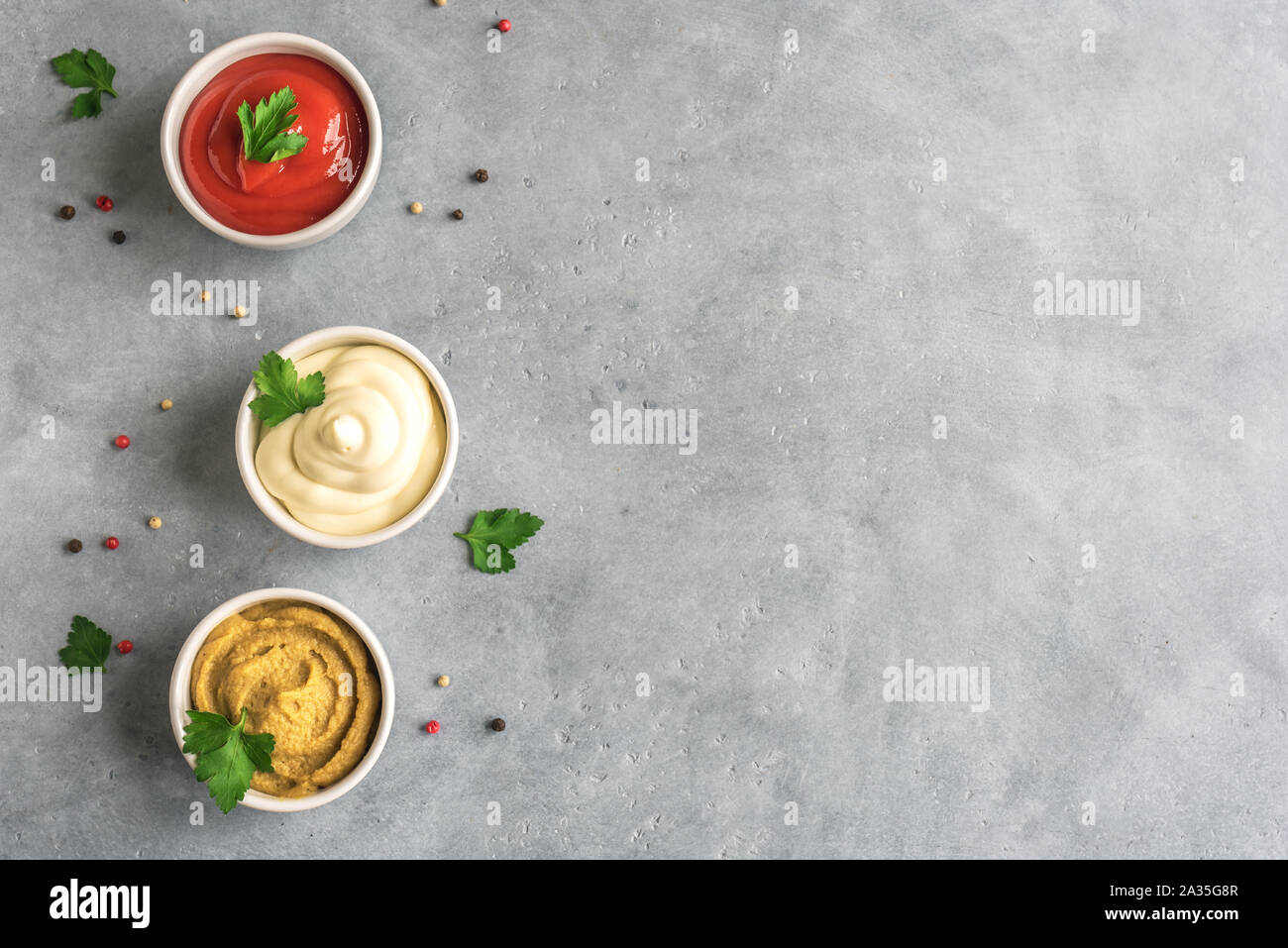 Ketchup, maionese e senape - Set di famose salse americane su calcestruzzo  sfondo, vista dall'alto, copia dello spazio. Tre le salse Foto stock - Alamy