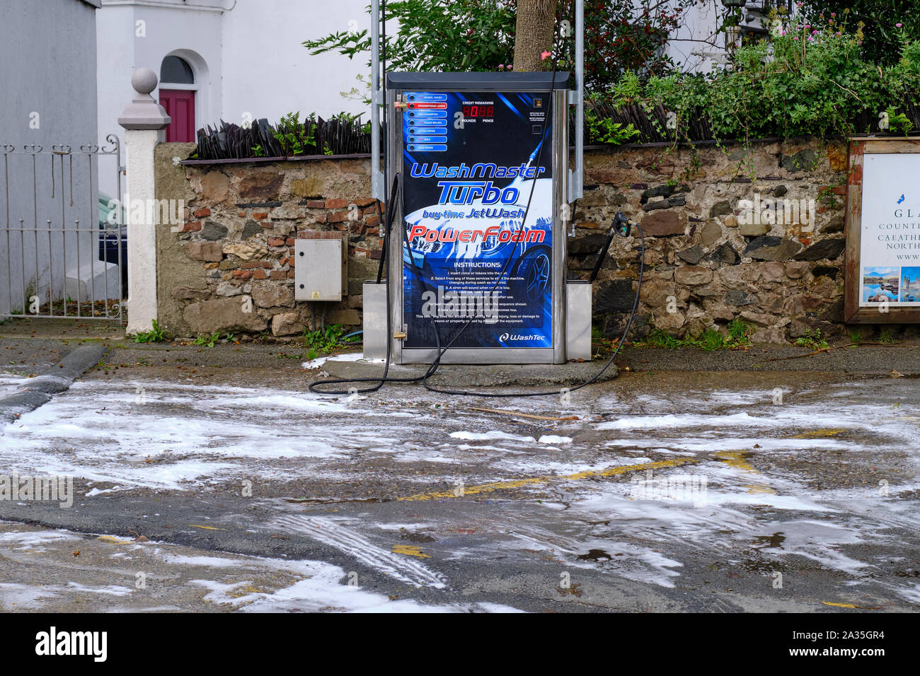 Washtec Schiuma di alimentazione auto auto stazione di lavaggio con sapone di residui di terreno di copertura a seguito di lavaggio in Welsh vie navigabili, a Caernarfon Galles. Foto Stock