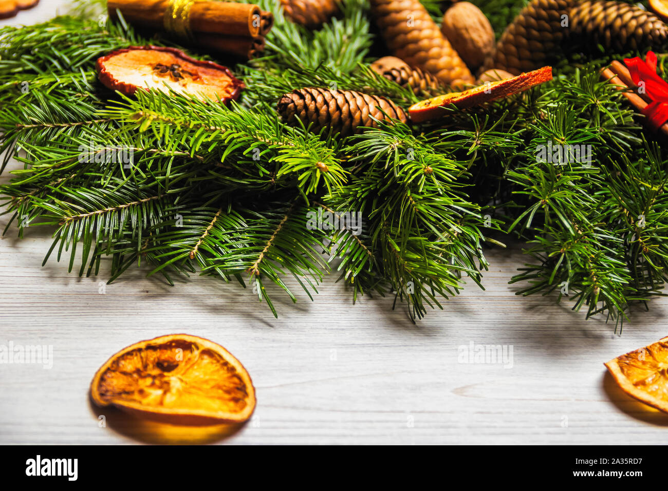 Nuovo anno di vacanza decorazioni. Fatte a mano ghirlanda di Natale di Abete rami con dadi, cannella e frutta secca spolverato con neve artificiale Foto Stock