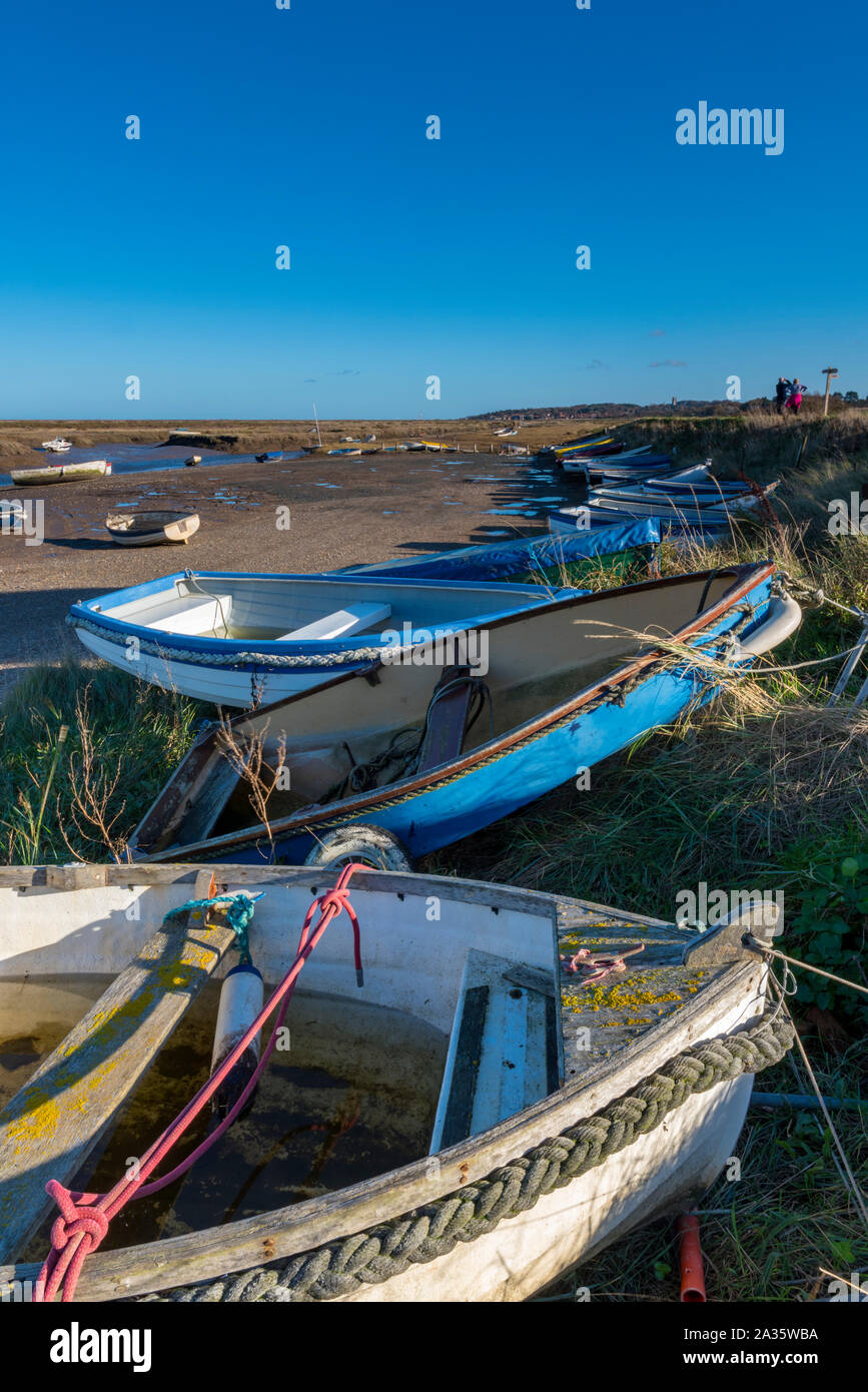 Piccole barche a remi e gommoni ormeggiate sul litorale nel porto di Morston vicino a pozzi vicino al mare sulla costa nord di norfolk. Foto Stock