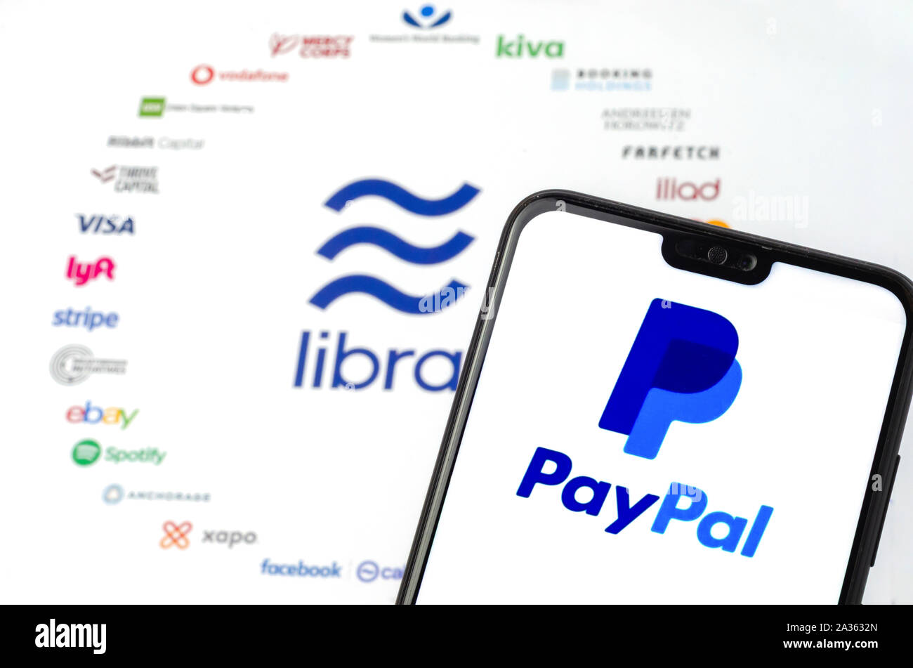 La Libra logo Associazione su carta per brochure e il logo di PayPal sullo schermo dello smartphone. A titolo illustrativo per le notizie che PayPal esce dall'Associazione. Foto Stock