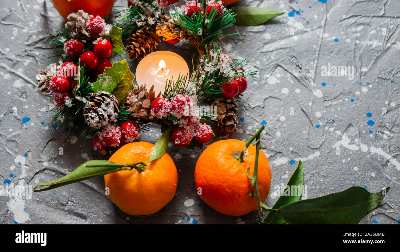 Nuovo anno e lo sfondo di Natale. Natale tangerini caramelle e candele su un colore grigio-blu sullo sfondo. Nuovo anno e composizione di Natale, copyspace f Foto Stock