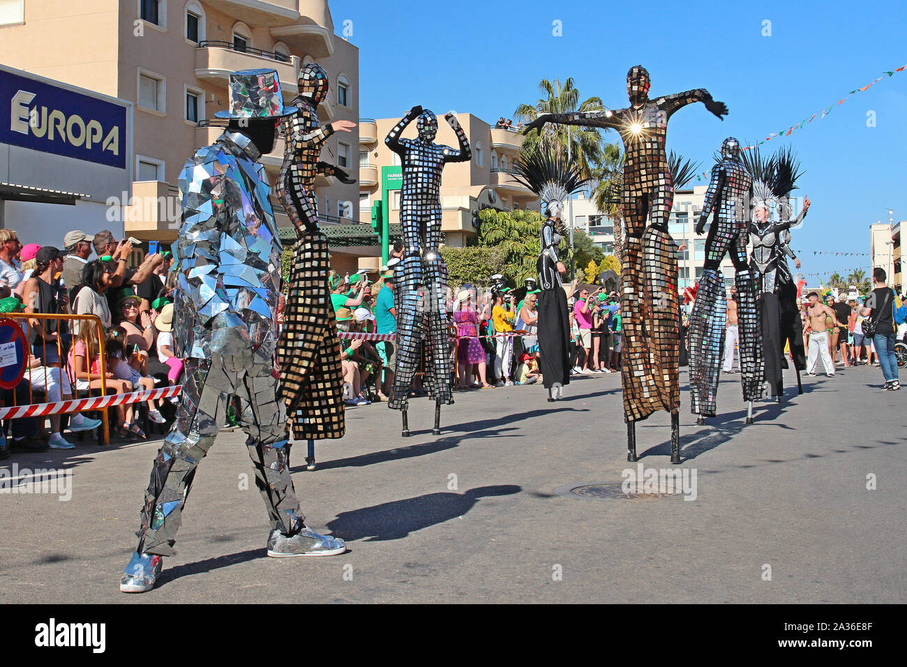 Cabo Roig, Provincia di Alicante, Spagna ospita uno dei più grandi celebrazioni della festa di San Patrizio al di fuori dell'Irlanda. Stilt artisti in costumi di specchi. Foto Stock