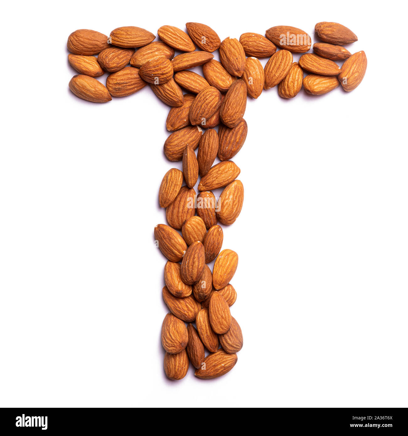 La lettera 'T' dell'alfabeto inglese da una mandorla pelata su un isolato bianco sullo sfondo. Mandorle pelate pattern. cibo sano concetto. Lettere f Foto Stock La lettera 'T' dell'alfabeto inglese da una mandorla pelata su un isolato bianco sullo sfondo. Mandorle pelate pattern. cibo sano concetto. Lettere f Foto Stock