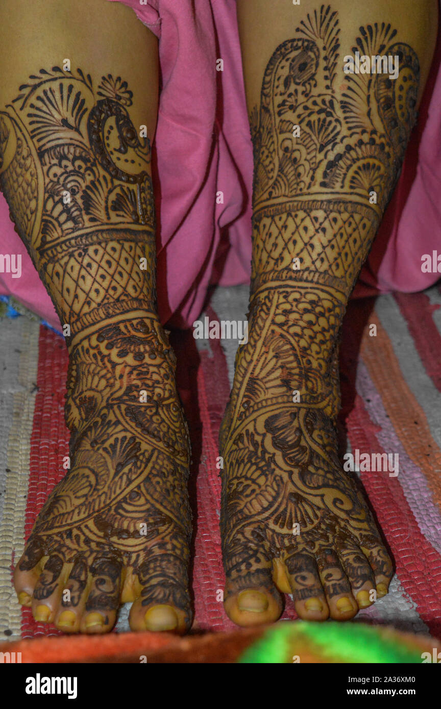 Una signora piedi con indian heena mehandi in matrimoni indiani. Foto Stock