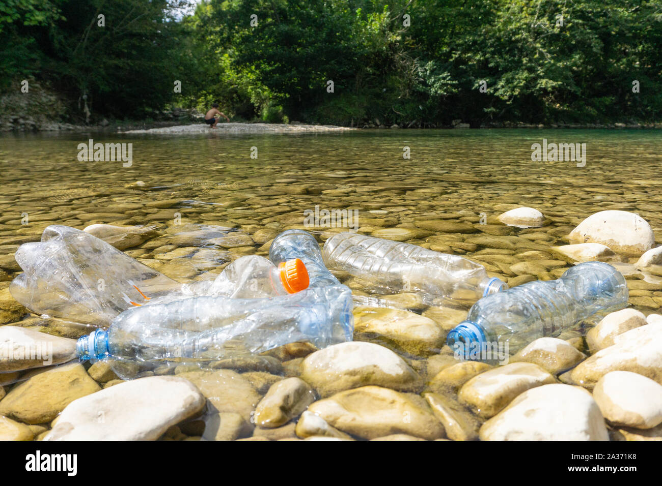 Inquinamento di plastica nel fiume. Sporchi le bottiglie e i sacchetti di plastica su un bidone della spazzatura. L'inquinamento del fiume, plastica in acqua. Inquinamento e riciclare il concetto di eco. Foto Stock