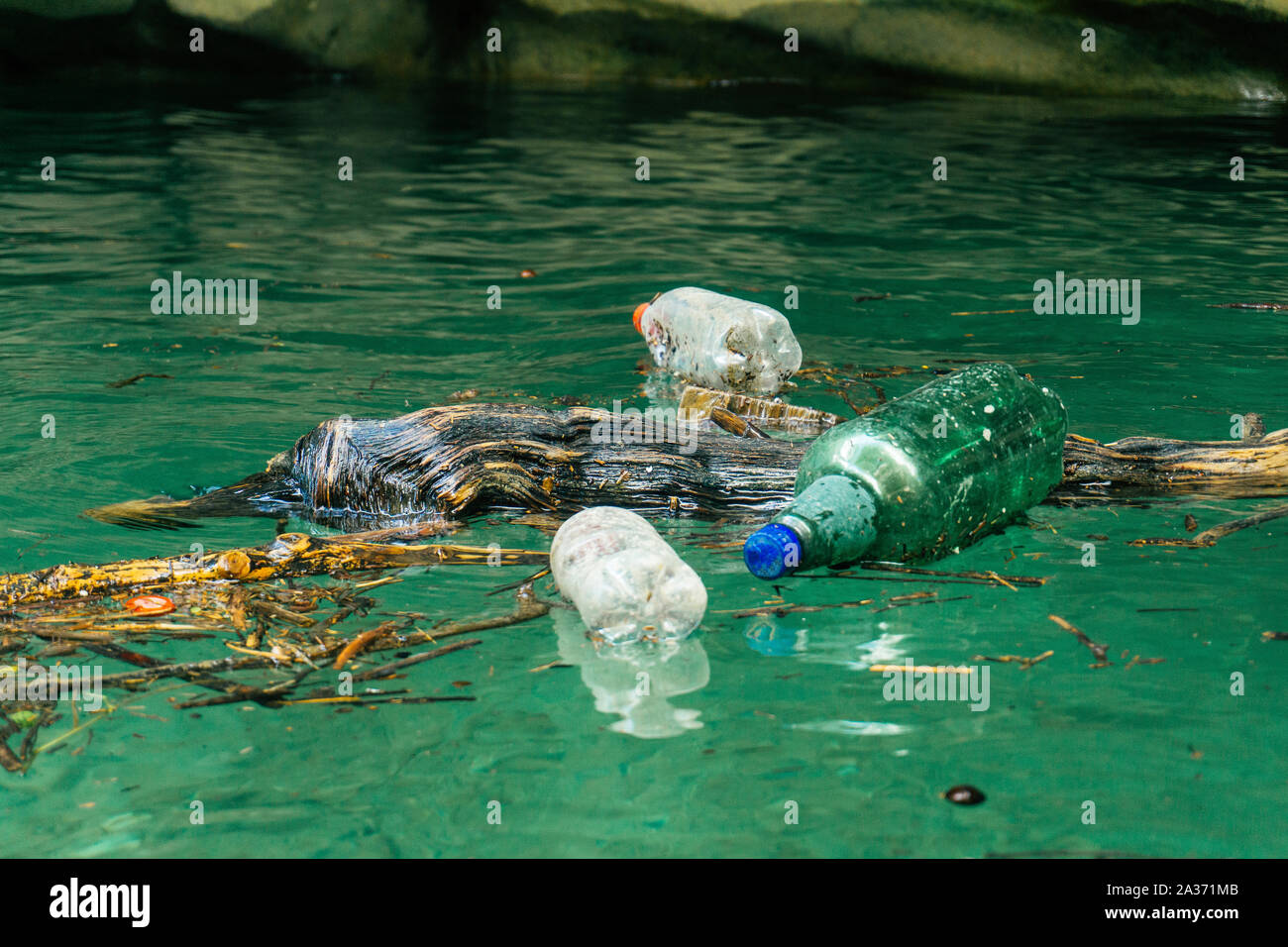 Inquinamento di plastica nel fiume. Sporchi le bottiglie e i sacchetti di plastica su un bidone della spazzatura. L'inquinamento del fiume, plastica in acqua. Inquinamento e riciclare il concetto di eco. Foto Stock