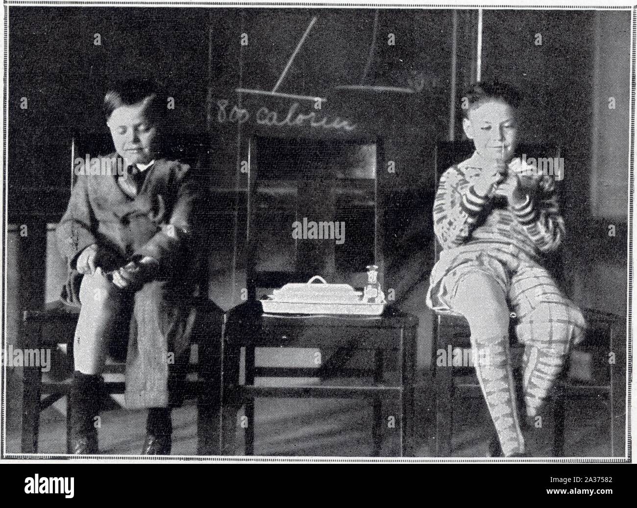 Deux pets diabétiques étiques se faisant eux-memes des injections hypodermiques d'insuline.1930 Foto Stock