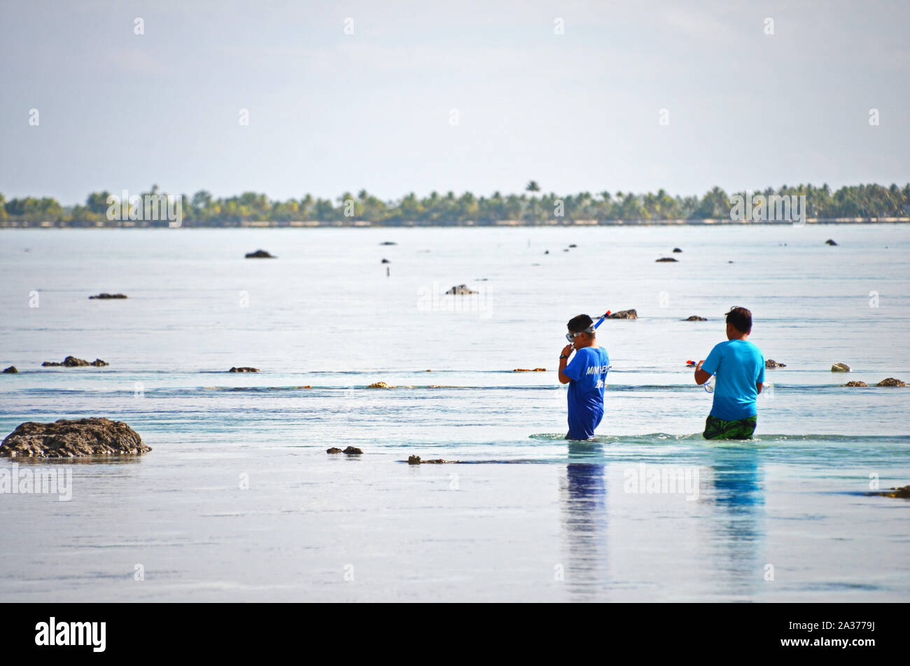 Due studenti della scuola wade in laguna su Anaa Atoll, Polinesia Francese Foto Stock