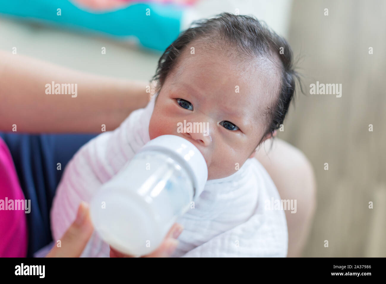 Asian Baby girl succhiare il latte dal flacone, kid bere latte Foto Stock