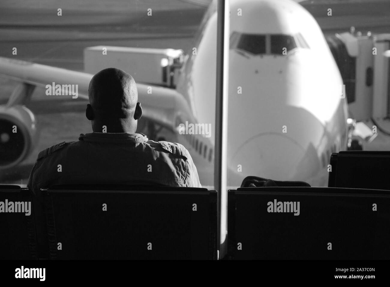 Johannesburg Gauteng, Sud Africa - 16 Luglio 2009: Africana passeggero seduto in sala in attesa per il suo volo, cercando di aereo parcheggiato su Tambo In Foto Stock