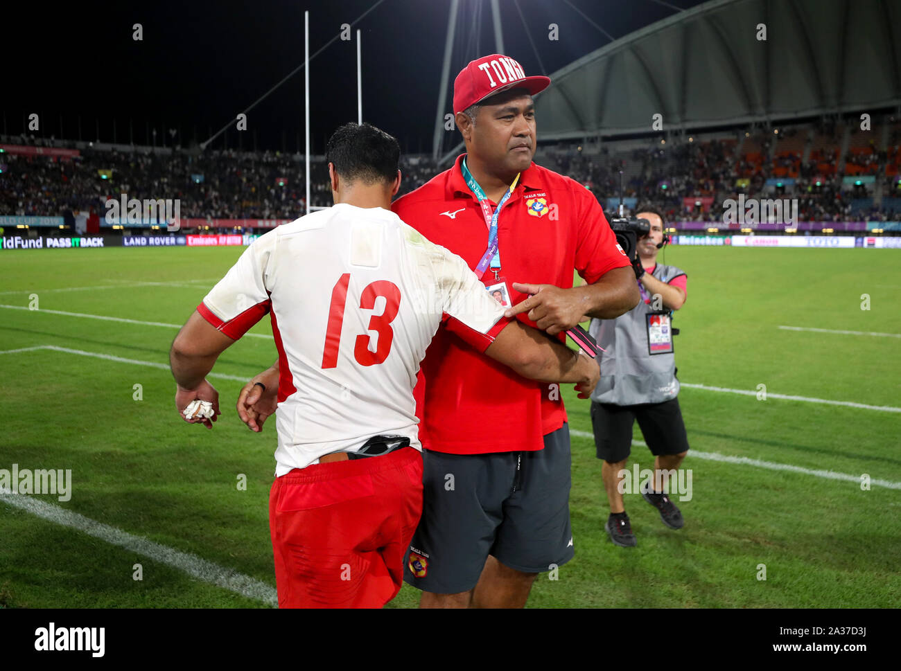 Tonga Head Coach Toutai Kefu con Tonga's Malietoa Hingano dopo il 2019 Coppa del Mondo di Rugby Pool C corrispondono a stadio di Kumamoto. Foto Stock