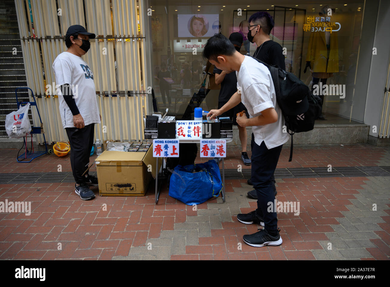 Il Causeway Bay Hong Kong dal 6 ottobre 2019 migliaia di persone, la maggior parte di essi indossano maschere come un gesto di protesta, marciò sotto la pioggia battente che condanna antimascheramento legge che vieta ai cittadini provenienti da indossare maschere nel corso legale e illegale di assembly. una cabina prendendo le donazioni e distribuendo gratuitamente le maschere. Foto Stock