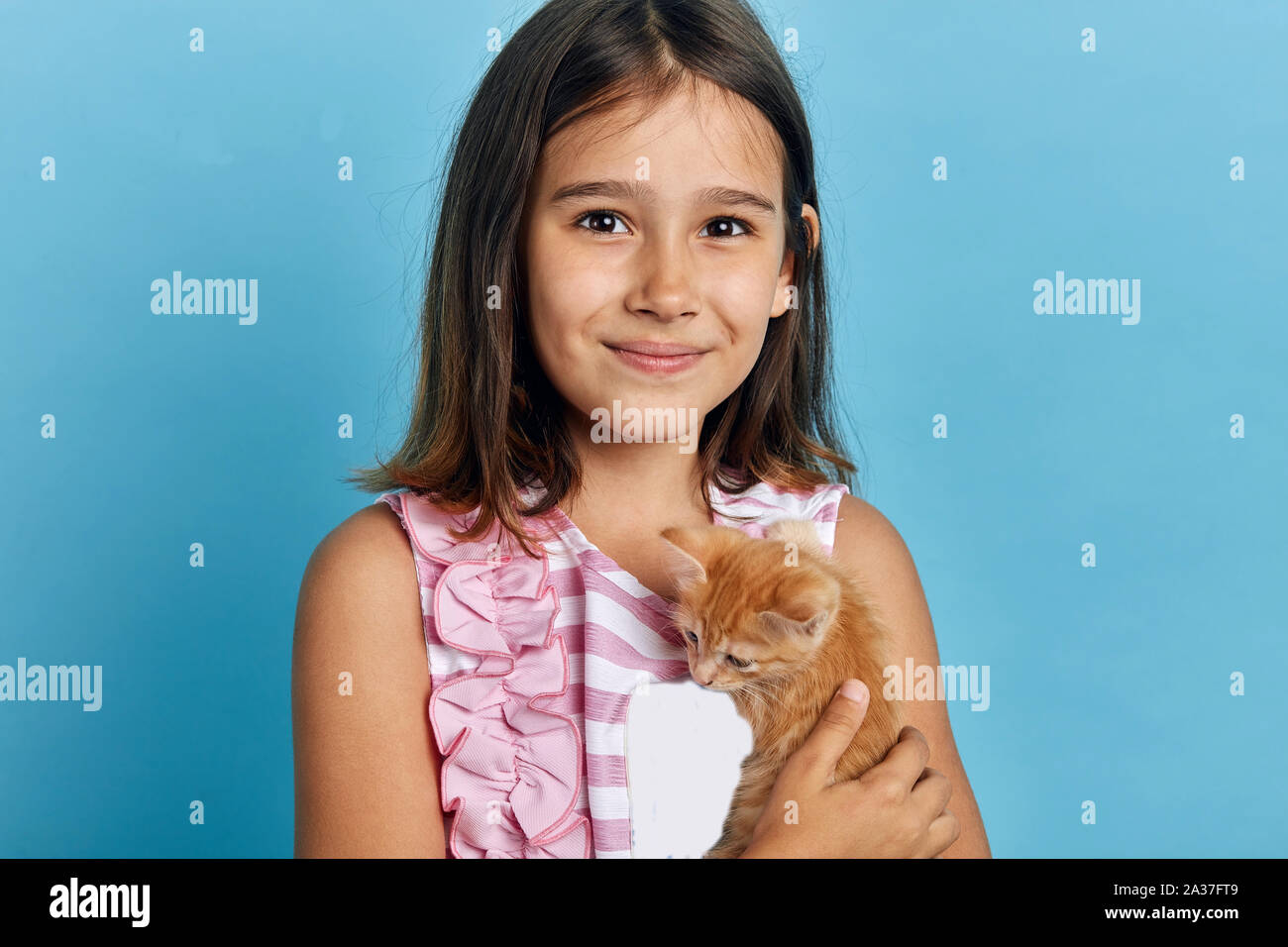 Attraente sorridente bambina abbracciando il suo gattino arancione, guardando la telecamera. close up ritratto, tempo libero, hobby Foto Stock