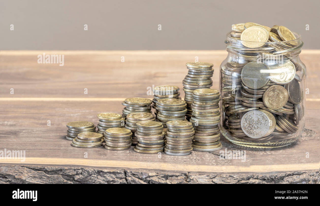 Le monete d'oro disposti in altezza e in un vaso Foto Stock
