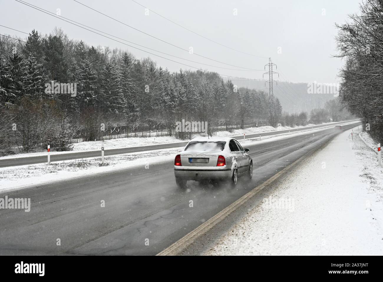 Vetture su strada in inverno con la neve. Pericoloso traffico automobilistico in cattive condizioni atmosferiche. Foto Stock