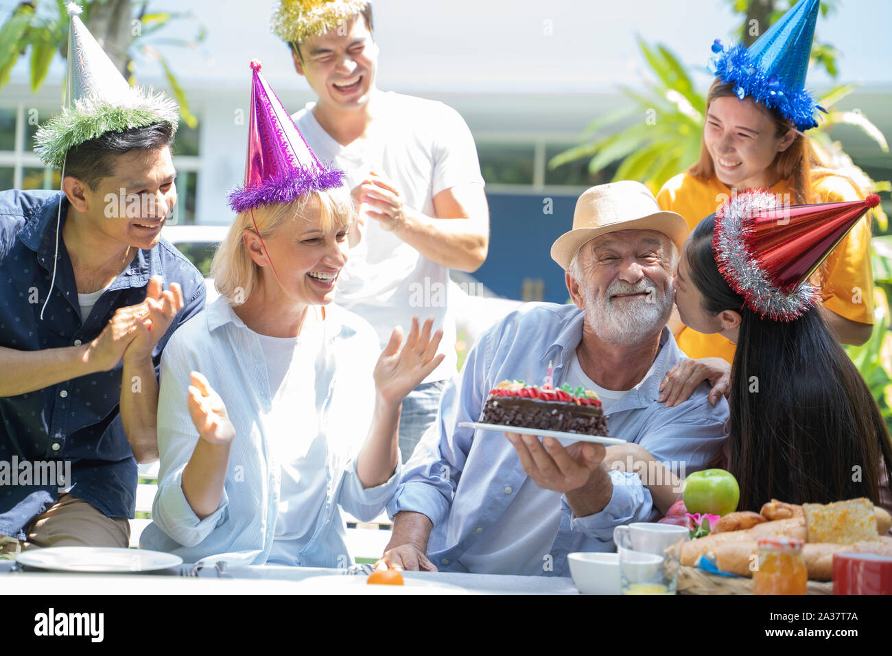 I membri della famiglia festeggiare il compleanno del senior. Foto Stock