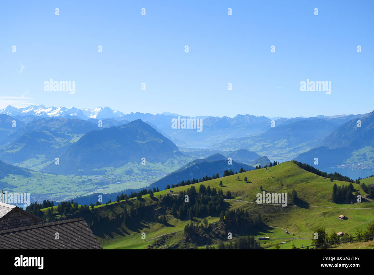 Panoramica vista del paesaggio di prati, catene montuose e cime innevate dalla sommità del Monte Rigi Kulm, Monte Rigi in Svizzera Foto Stock
