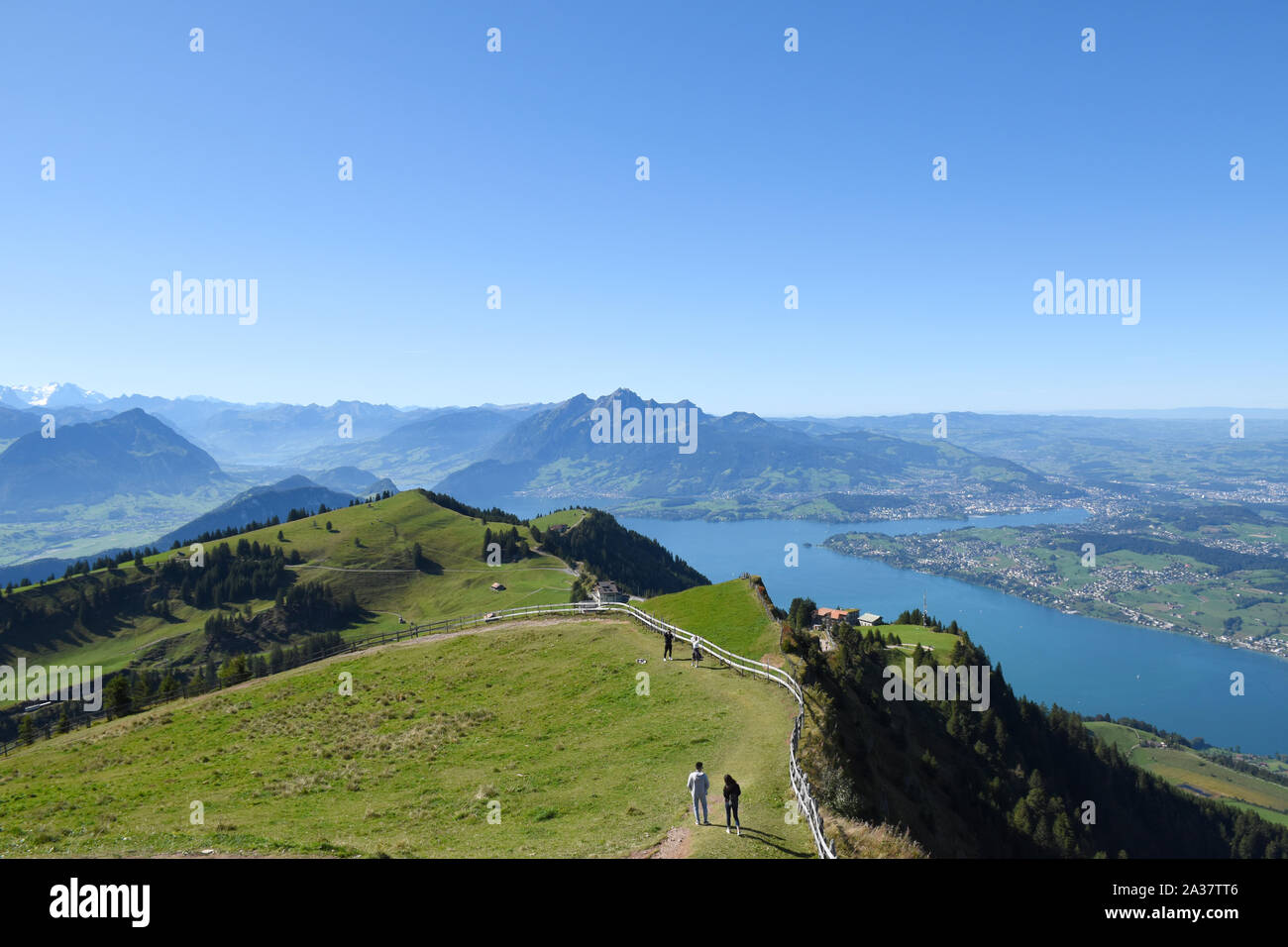 Panoramica vista del paesaggio di prati, catene montuose con cime innevate dalla sommità del Monte Rigi Kulm, Monte Rigi in Svizzera con il lago di Lucerna Foto Stock