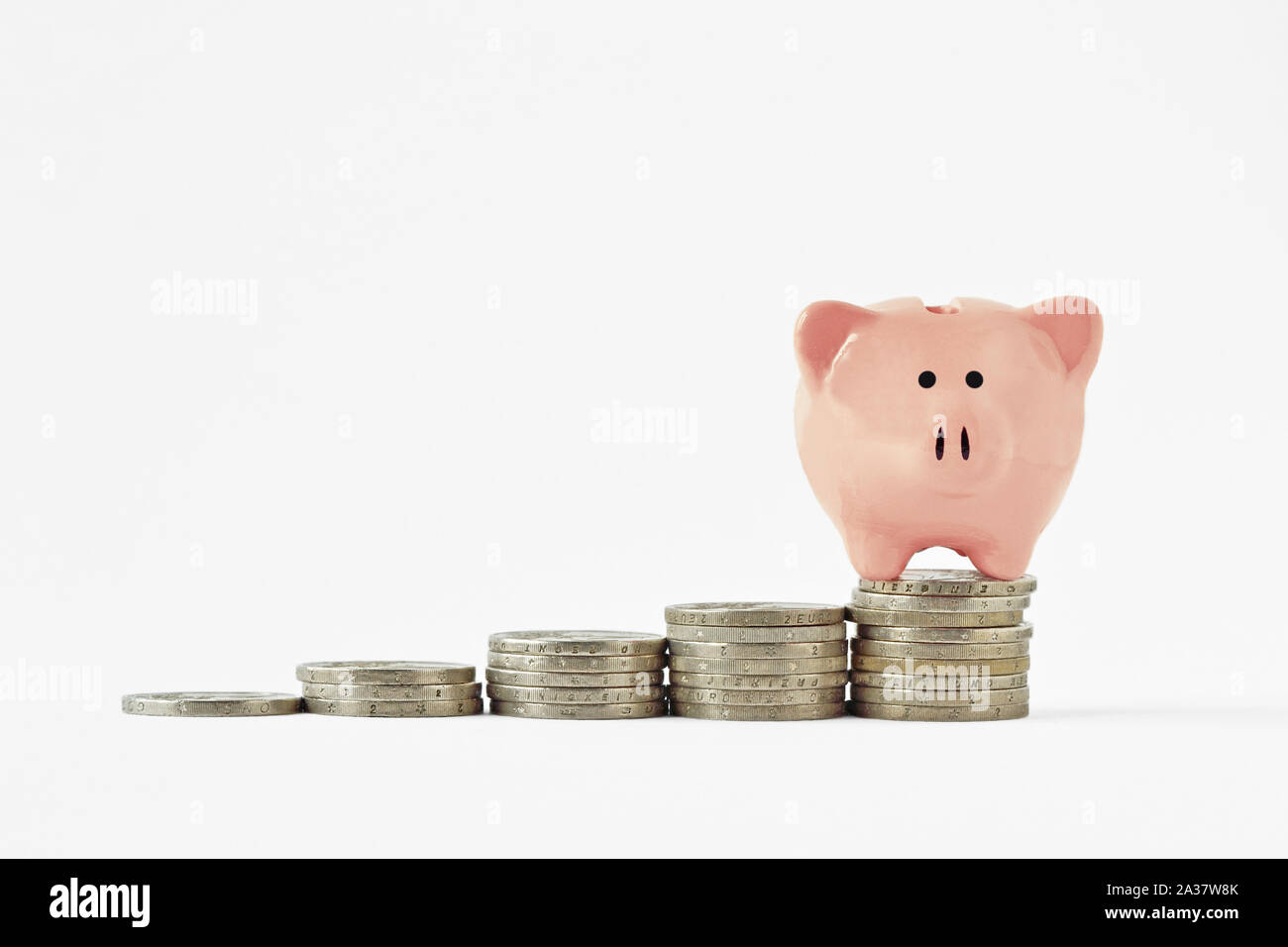 Salvadanaio sul sollevamento delle pile di monete - Concetto di risparmio di denaro Foto Stock