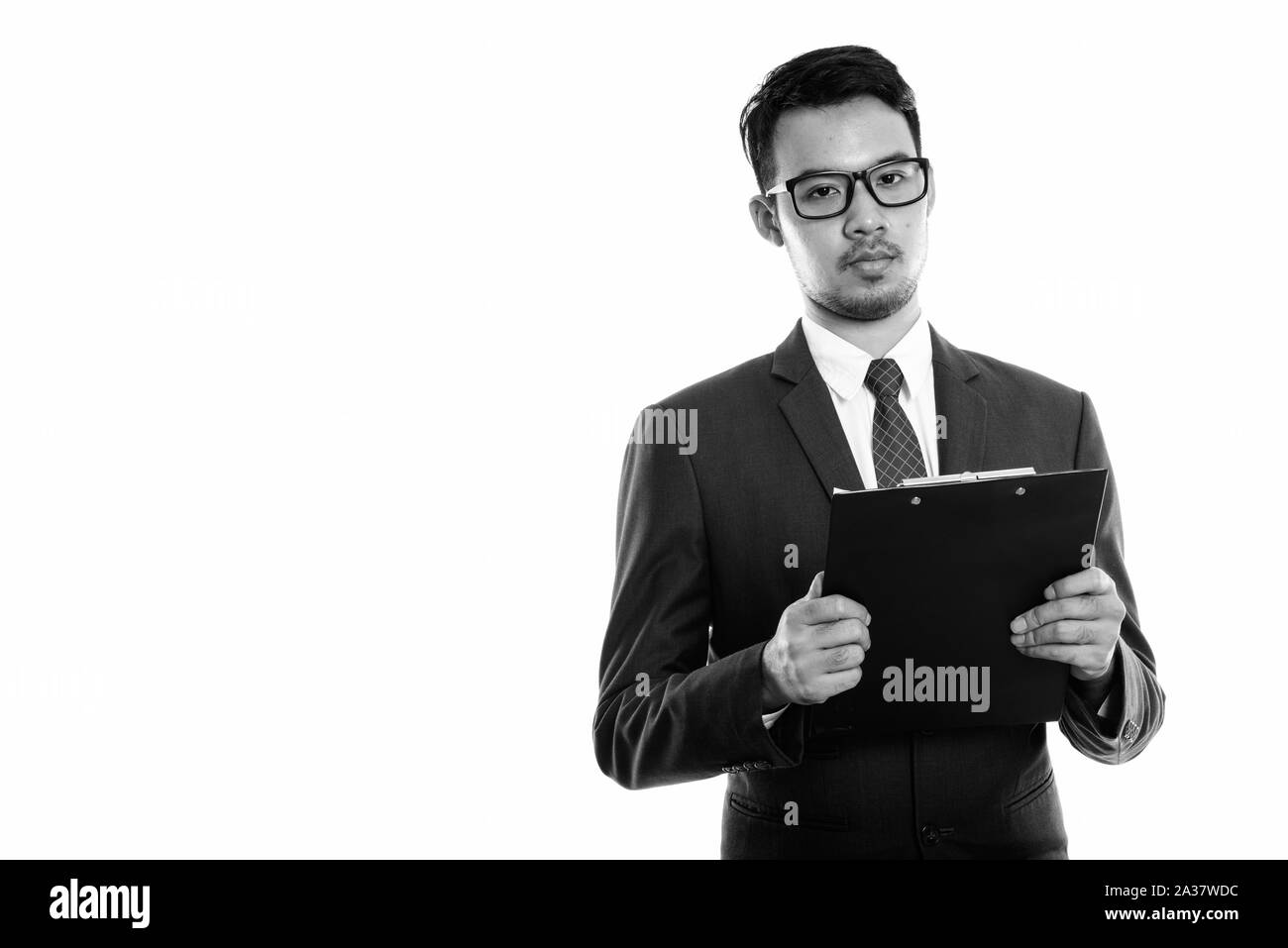 Studio shot del giovane imprenditore asiatici holding negli appunti Foto Stock