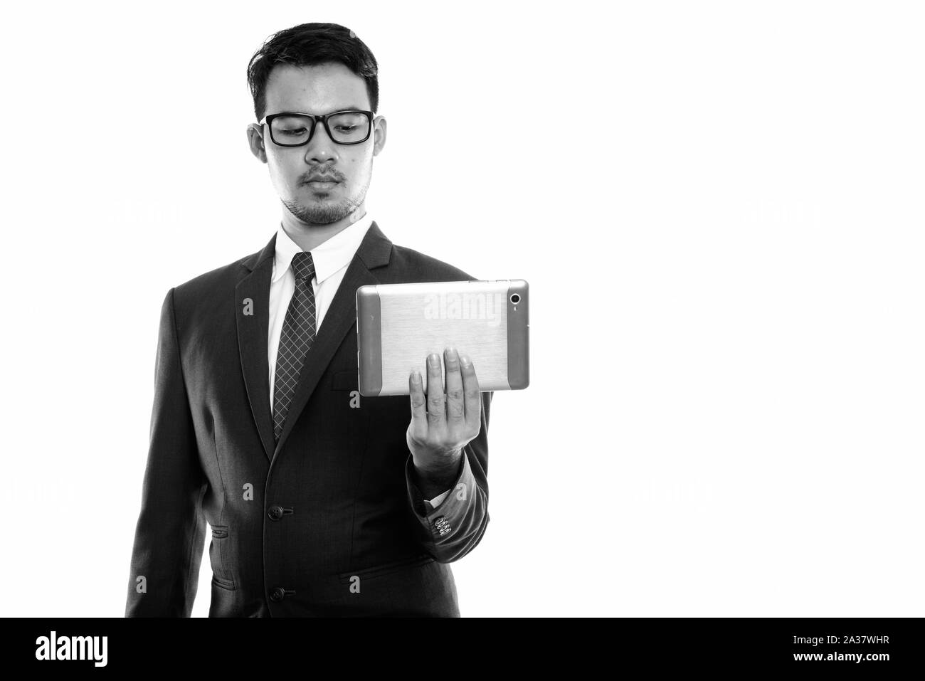 Studio shot del giovane imprenditore asiatici holding tavoletta digitale Foto Stock