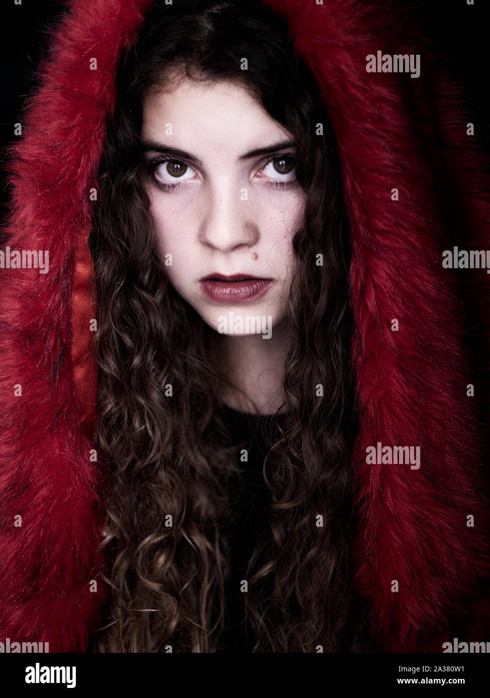 Giovane e bella donna che indossa red fake fur hoodie Foto Stock