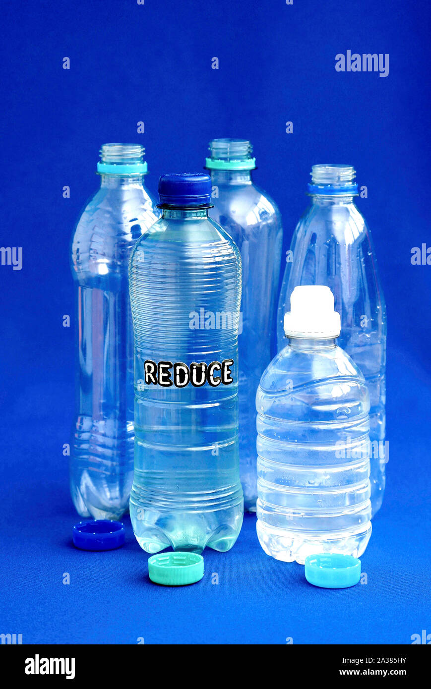 Piccola bottiglia di plastica con la parola ridurre (inquinamento ambientale concetto) Foto Stock