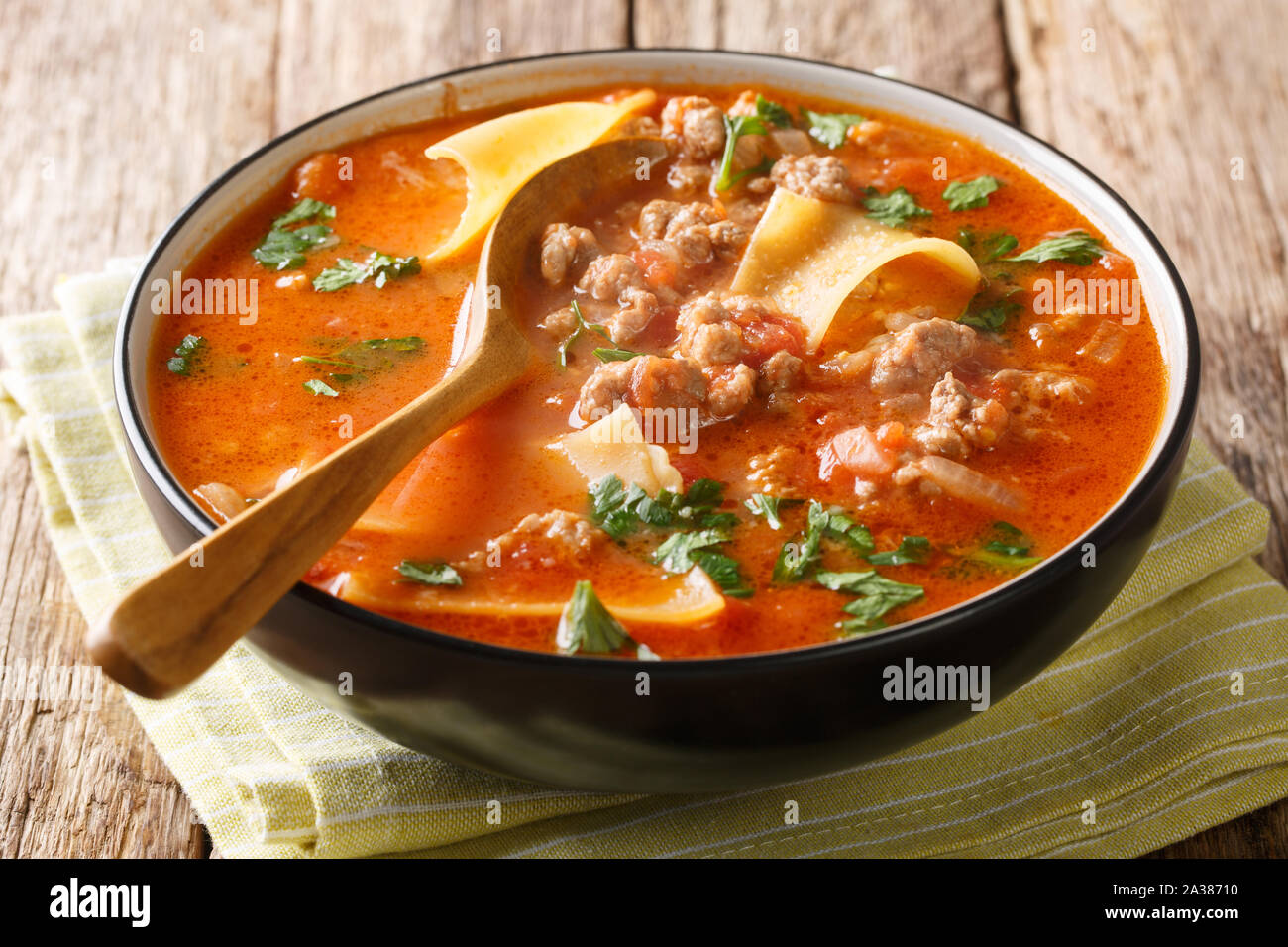 Parte della ricca zuppa di lasagne close-up in una piastra sul tavolo orizzontale. Foto Stock