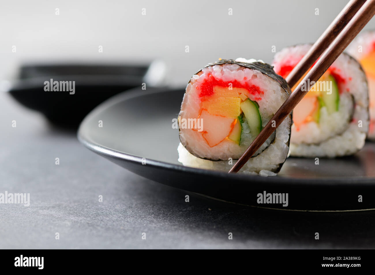 Rotoli di sushi (vegetali, Inari e bastoncini di granchio) con bacchette, popolare il cibo giapponese Foto Stock