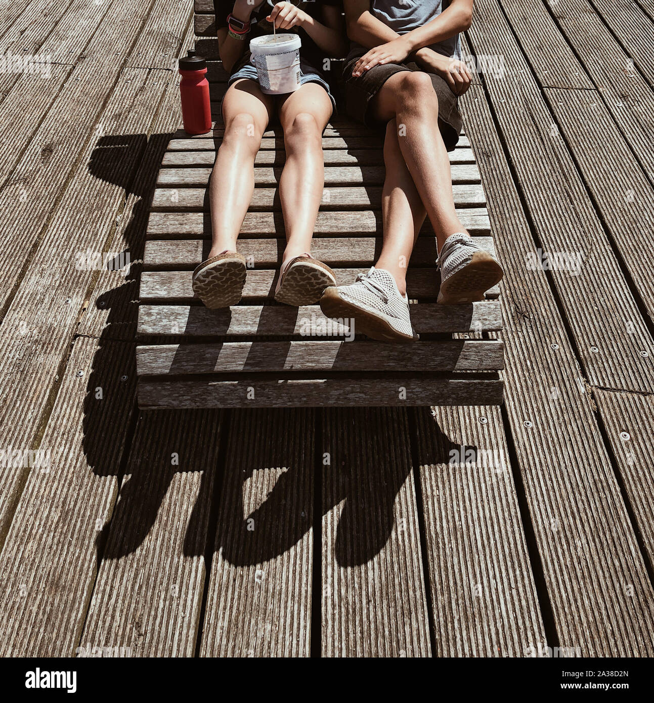 Un ragazzo e una ragazza seduta su una sedia di sun su una terrazza, Danimarca Foto Stock