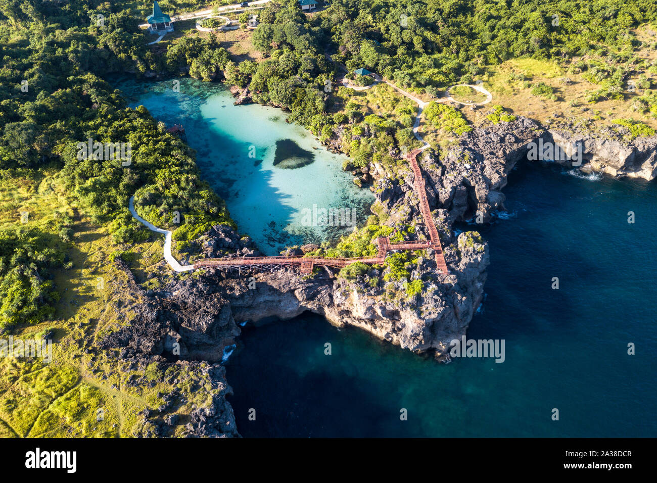 Il sentiero attraverso le rocce tra il lago di acqua salata e oceano, lago Weekuri, Sumba, Nusa Tenggara orientale, Indonesia Foto Stock