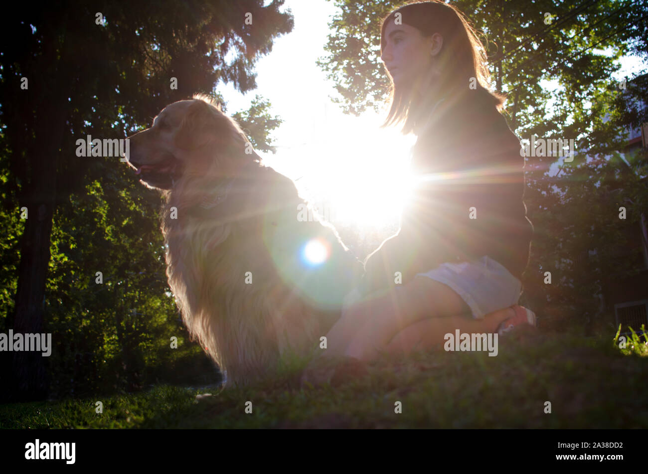 Ragazza seduta nel parco con il suo cane, Argentina Foto Stock