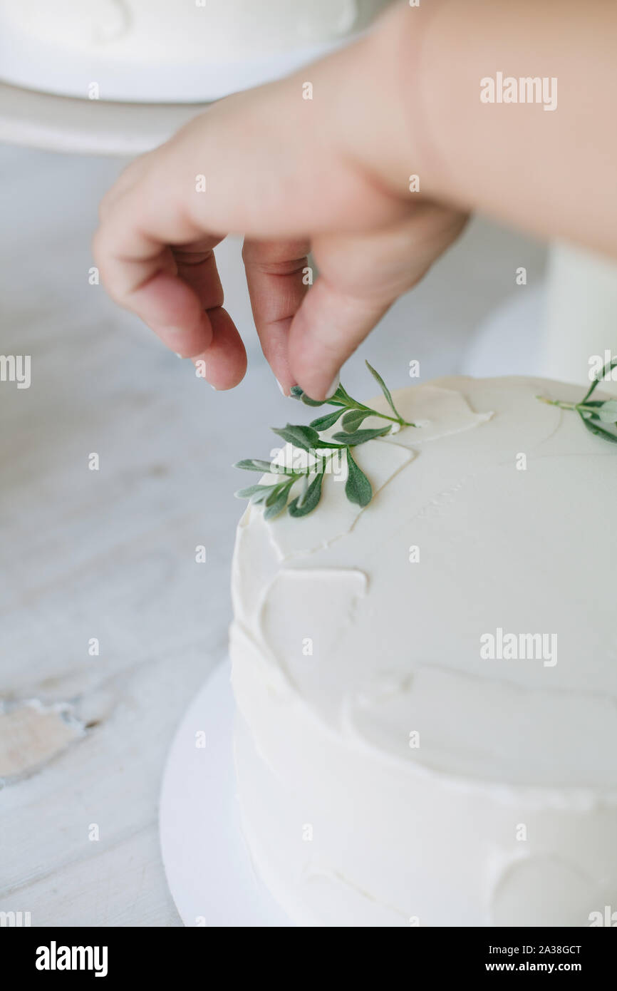 Donna decorare una torta con foglie Foto Stock