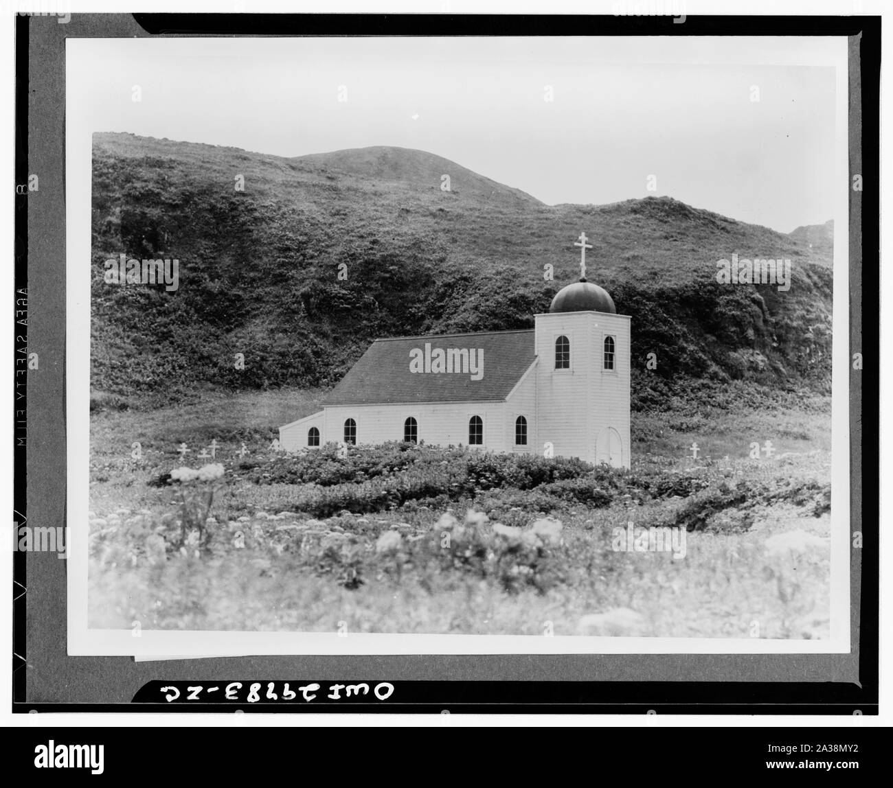 Chiesa ortodossa russa e il cimitero di Isola di attu, Alaska, 1938. Costruito nel 1932, ha sostituito una vecchia chiesa che era un erba-barabara coperto costruito di driftwood. La chiesa ha servito la comunità di 34 Aleutians nel villaggio di attu prima della II Guerra Mondiale (Attu prima della guerra). Didascalia originale: Questa è la chiesa ortodossa russa a attu Village. Essa prestava servizio alle necessità spirituali dei due cliente indigeni che vivono sul isola di attu al momento dell'invasione giapponese. Alcune dell'isola la ricchezza dei fiori può essere visto entrare in bloom accanto alla chiesa. I visitatori del Aleutians hanno espresso su Foto Stock
