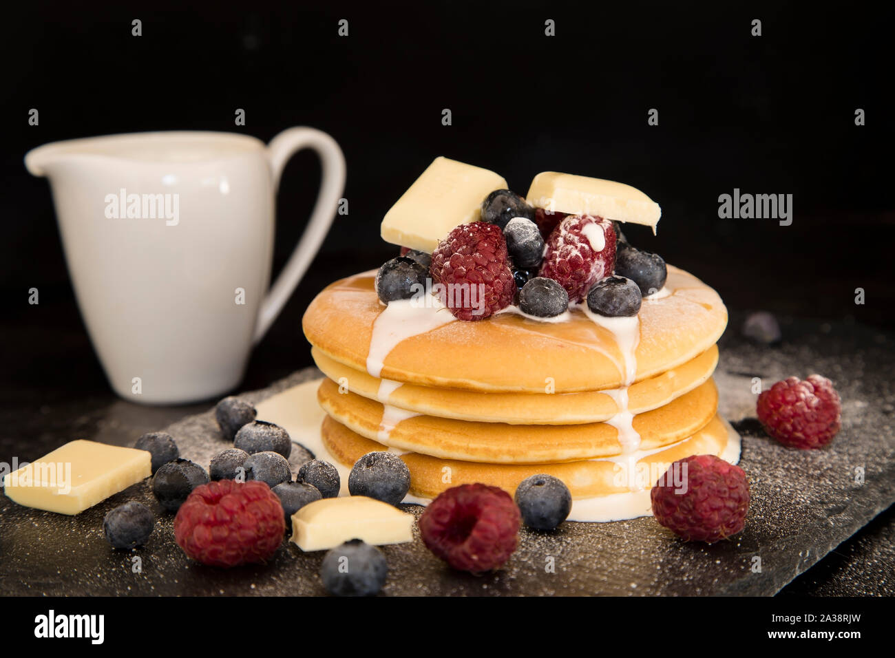 Frittelle con frutti di bosco, cioccolato bianco e crema di latte Foto Stock