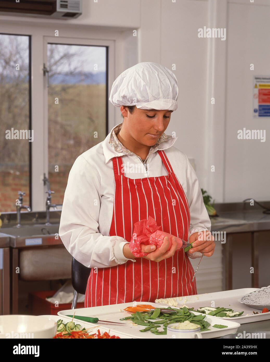 Studentessa lavora nel catering e classi di cucina, Guildford, Surrey, England, Regno Unito Foto Stock