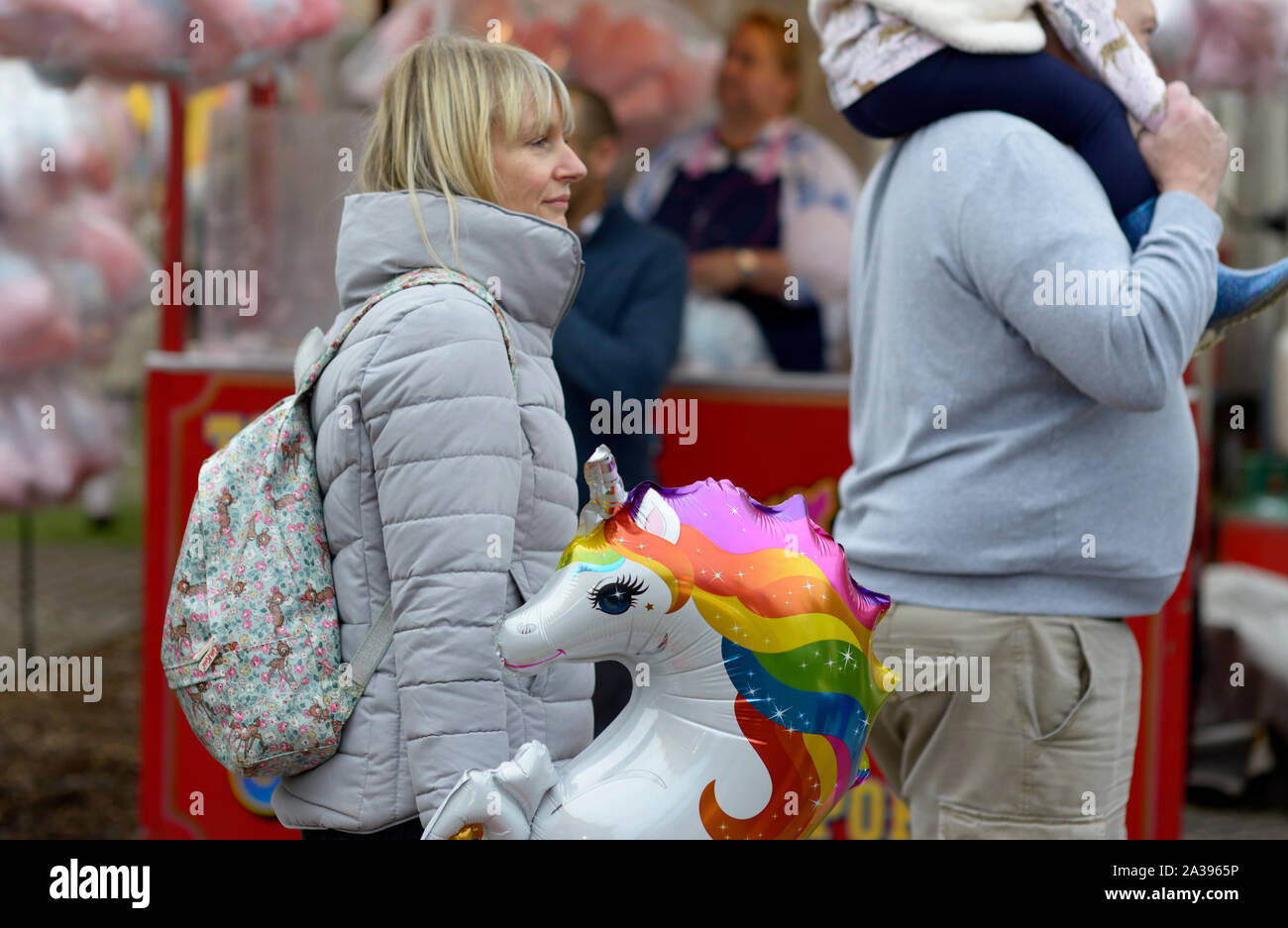 Signora bionda con Blow up Unicorn, alla fiera d'oca, Nottingham Foto Stock