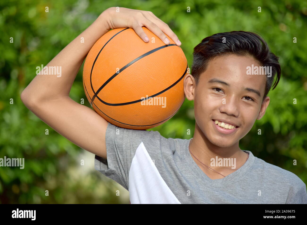 La Gioventù Maschile asiatica del giocatore di basket e la felicità con basket Foto Stock