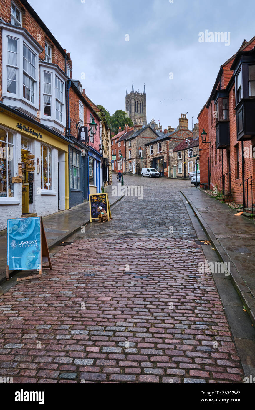 Una vista guardando up Steep Hill a Lincoln, Inghilterra verso la gotica Cattedrale in stile Foto Stock
