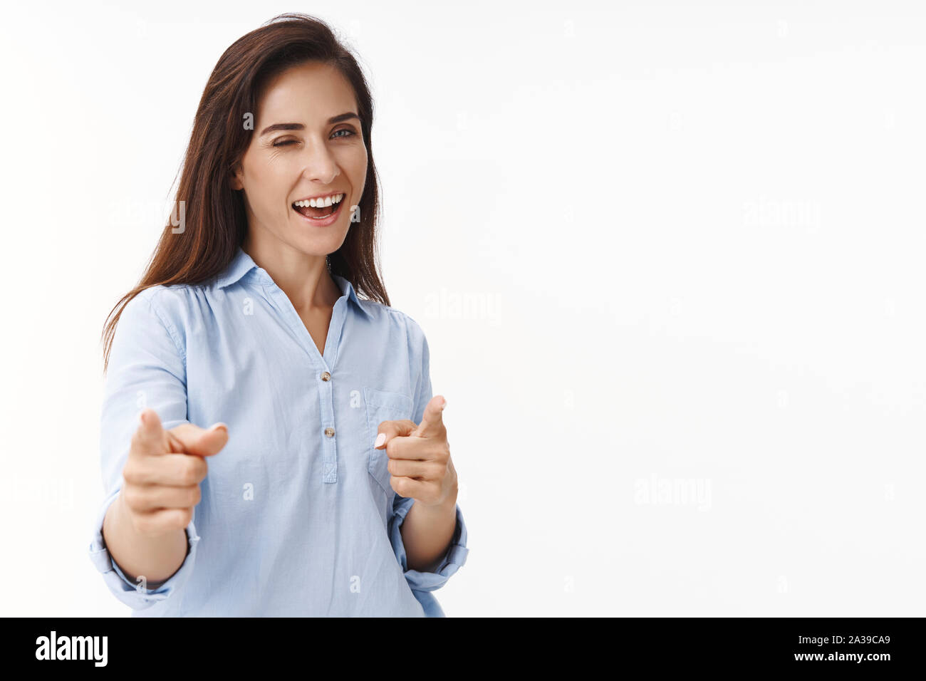 Successo ambizioso brunette donna 30s congratularmi con il collega buon lavoro, puntando il dito della fotocamera pistole, wink intrattenuti con gioia, sorridono felici Foto Stock