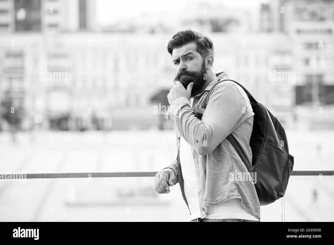 Tourist bello hipster con zaino stand street. Uomo con la barba e zaino esplorare la città. Viaggi e avventure del concetto. Turisti in vacanza. Hipster turista moderno background urbano. Foto Stock