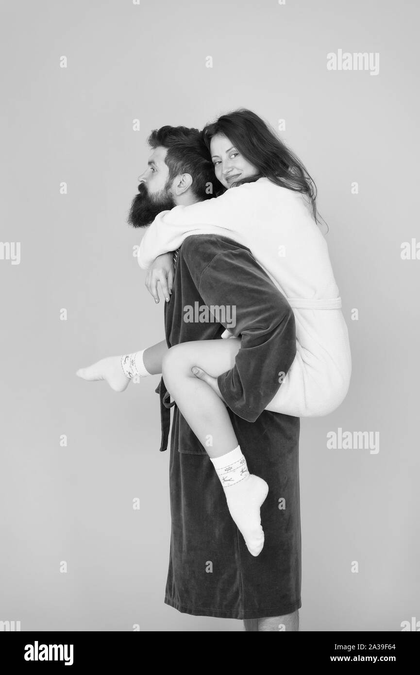 Matura in accappatoi avendo divertimento. La fiducia e il supporto. Il vero amore. Consente di rimanere a casa. Essi sono gente più vicina. Il supporto in qualsiasi momento. Supporto affidabile. Bel giovane piggybacking bella donna. Foto Stock